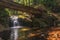 Bubbling foamy waterfalls under wooden bridge.