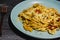 Bucatini pasta with tomatoes and veggies and vegan cheese