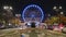 Bucharest ferris wheel for Christmas market, in front of the Parliament building, with cars going by at rush hour. Night timelapse