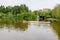 Bucharest, Romania - 1 May 2021: One dragon boat on water and green weeping willow trees on the shoreline of Titan Lake in