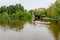 Bucharest, Romania - 1 May 2021: One dragon boat on water and green weeping willow trees on the shoreline of Titan Lake in