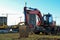 Bucked wheel excavator digs ground at a construction site for installing concrete storm pipes. Backhoe the digging pipeline ditch