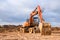 Bucked wheel excavator digs ground at a construction site for installing concrete storm pipes. Backhoe the digging pipeline ditch