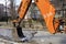 Bucket and arrow of a heavy road excavator on the repair of the sidewalk.