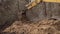 Bucket of backhoe digging soil at construction site. Crawler excavator digging. Excavating machine.