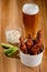 Bucket of Buffalo chicken drumsticks with celery sticks, ranch dip and beer