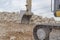 Bucket  and caterpillar of an excavator against stones and sky