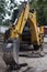 the bucket of a construction excavator breaks up the asphalt and removes building blocks