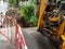 Bucket digger digging trench near house