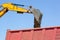 Bucket of an excavator pouring rock on the back of a truck