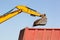 Bucket of an excavator pouring rock on the back of a truck