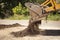 Bucket of excavator pours out the ground against the background of a rural industrial zone. Bulldozer work on the