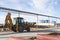 A bucket loader carries out loading of coal in an open port warehouse on a background of black mountains of coal