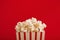 Bucket of popcorn on red background