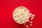 Bucket of popcorn on red background, top view