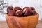 Buckeye Chestnut in wooden bowl on wooden surface. Side View formation of Fresh conkers