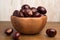 Buckeye Chestnut in wooden bowl on wooden surface. Side View formation of Fresh conkers