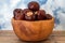 Buckeye Chestnut in wooden bowl on wooden surface. Side View formation of Fresh conkers