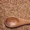 Buckwheat background with brown wooden spoon