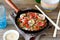 Buckwheat noodles with shrimp, peppers and tomatoes in a frying