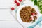 Buckwheat porridge with pieces of meat and a salad of radishes on a white wooden background.