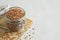 Buckwheat uncooked grains in glass jar on the wooden cutting board on gray background. Healthy, dietary food.