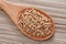 Buckwheat in a wooden spoon on soba noodles background