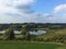 Bucolic English landscape in Suffolk county with lake, meadow and trees near the castle