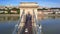 Budapest, Hungary - 4K flying above Szechenyi Chain Bridge with busy morning traffic at sunrise. Fisherman`s Bastion