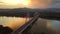 Budapest, Hungary - 4K flying away from Megyeri Bridge at sunset with heavy afternoon traffic with gloden sky and Buda Hills