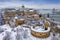 Budapest, Hungary - Aerial view of the snowy Buda Castle Royal Palace from above with the Szechenyi Chain Bridge and Parliament