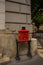 Budapest, Hungary. Bright red mailbox with a slot for letters, with a relief image of the mail horn, with legs supports