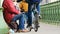 Budapest, Hungary - December 6, 2018: A hungry beggar sits on the asphalt of the bridge, holds an alms cup, and reads