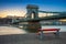 Budapest, Hungary - Famous Szechenyi Chain Bridge with traditional red bench and sightseeing boat