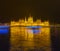 Budapest Parliament at the cold winter night with boats passing on Danube