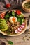 Buddha bowl dish with buckwheat porridge,boiled egg, fresh vegetable salad with avocado, radish, chard leaves, arugula, tomato and