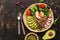 Buddha bowl dish with buckwheat porridge, fresh vegetable salad with avocado, radish, chard leaves, arugula, tomato and seeds,