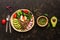 Buddha bowl dish with buckwheat porridge, fresh vegetable salad with avocado, radish, chard leaves, arugula, tomato and seeds,