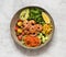 Buddha bowl salad with grilled prawns, arugula, avocado, corn, tomatoes and cucumbers.