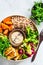 Buddha bowl with tofu, avocado, rice, seedlings, sweet potato and tahini dressing