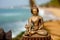 Buddha brass sculpture at ocean background