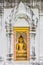Buddha image statue in concrete wall with Thai stucco decorations frame