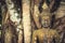 Buddha mossy stone sculpture among banyan tree trunks and roots as Asia travel background