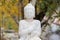 Buddha statue in autumn with hands folded over chest