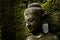 Buddha statue covered by moss in ancient temple