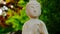 Buddha statue on a green garden background in the rays of the sun.Zen. Buddhism religion background.Calm, balance and