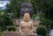 Buddha statue and Head of the big black bronze buddha statue in the lotus flower closeup. Ancient sculpture in the buddhist temple