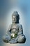 Buddha statue holds apple tree flower in the hands. Religious theme template.