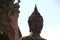 Buddha statue outside temple in ruins, Thailand