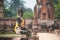 Buddha statue with yellow robe and ruin buildings